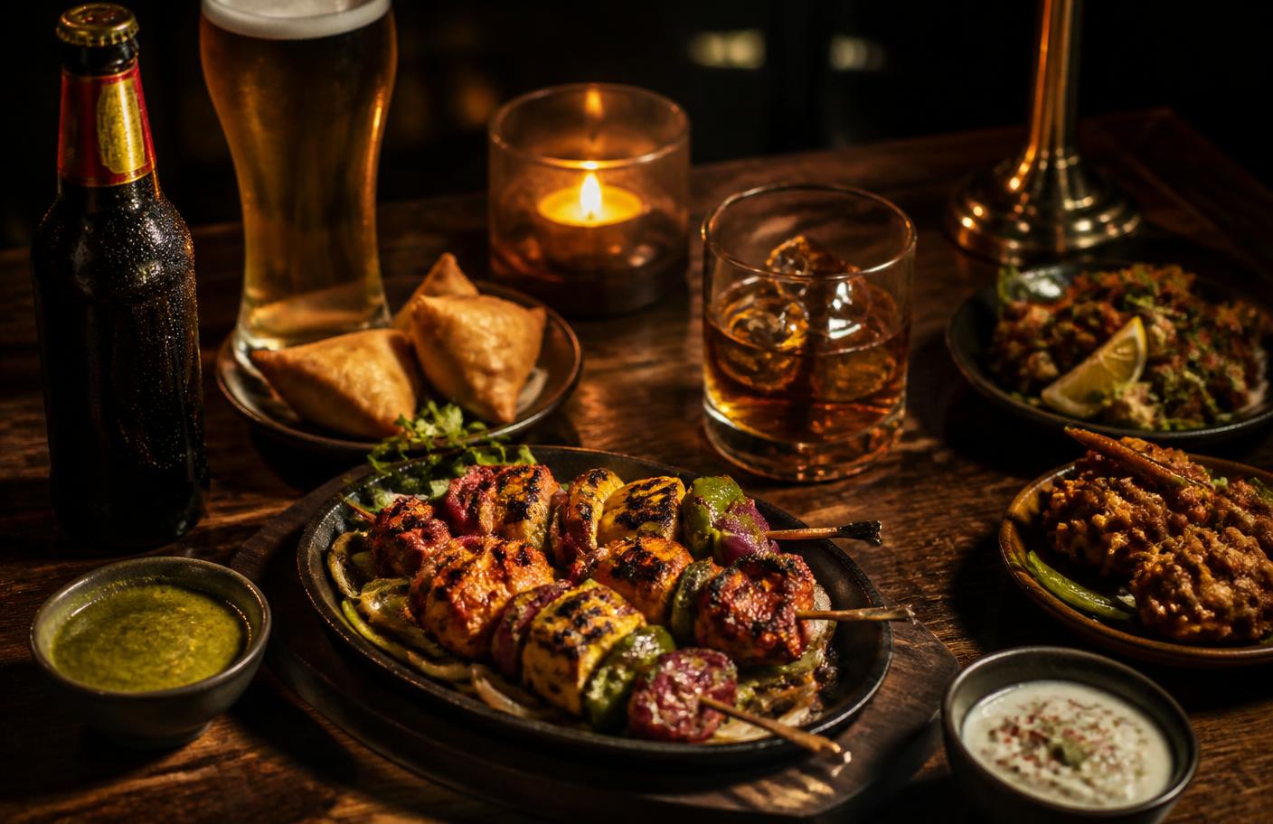 Indian curries, biryani and naan on a dark table